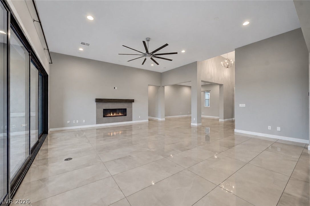 Polished tile flooring and a modern fireplace elevate this spacious, open-concept living area.