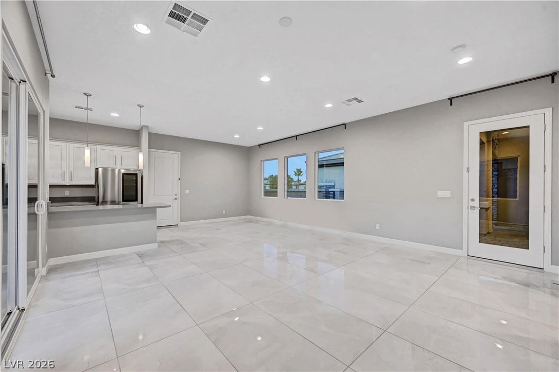 Polished tile flooring and recessed lighting define this spacious open living area.