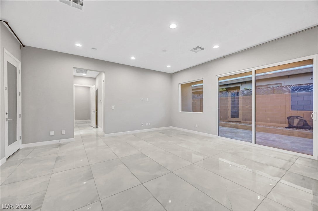 Polished tile flooring and expansive sliding glass doors define this open living space.
