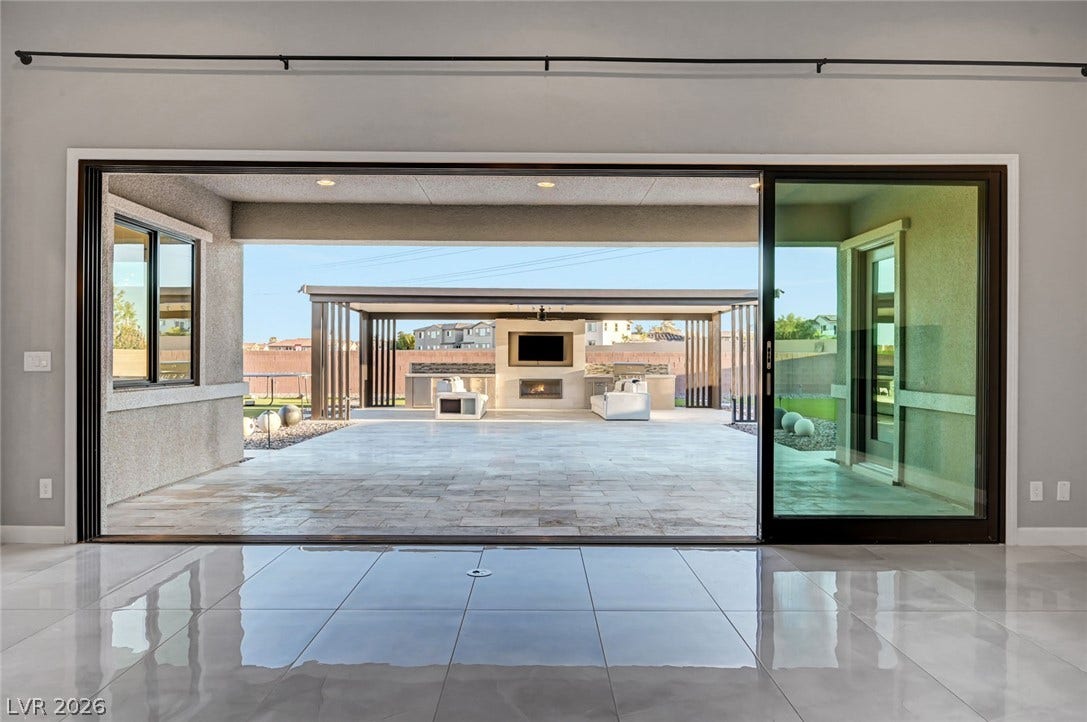 Massive sliding glass doors bridge the indoor living space with a polished outdoor patio.