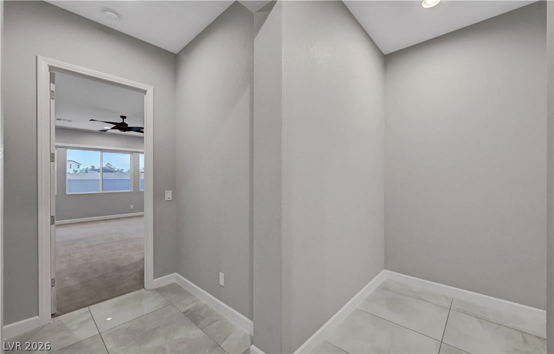 Gleaming tile floors lead into a spacious carpeted bedroom visible through the wide doorway.