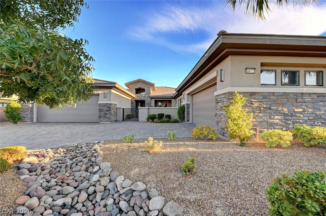 Textured stone accents and desert landscaping define the exterior of this modern single-story residence.