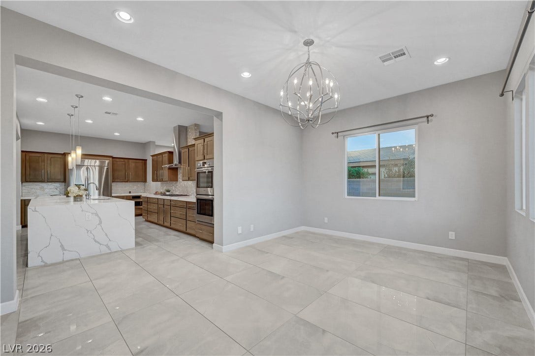 Polished tile flooring flows seamlessly from the formal dining space into the gourmet kitchen.