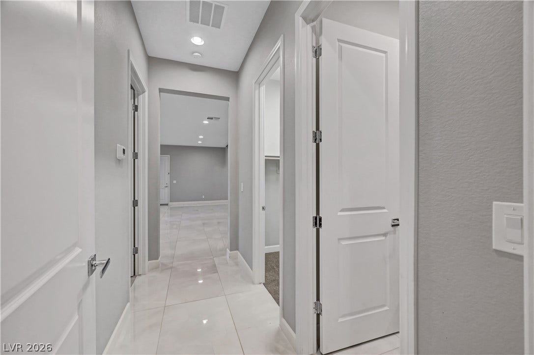 Polished tile flooring and clean lines define this modern hallway transition.