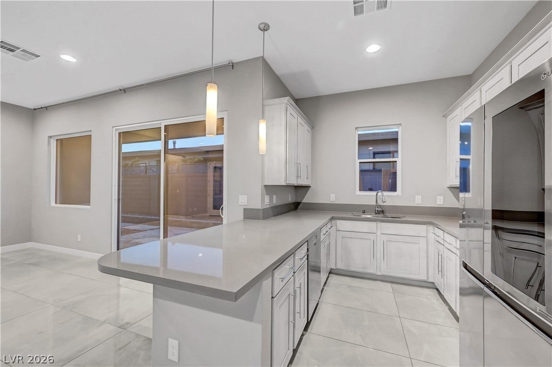 Polished tile flooring and quartz countertops highlight this modern cooking space.