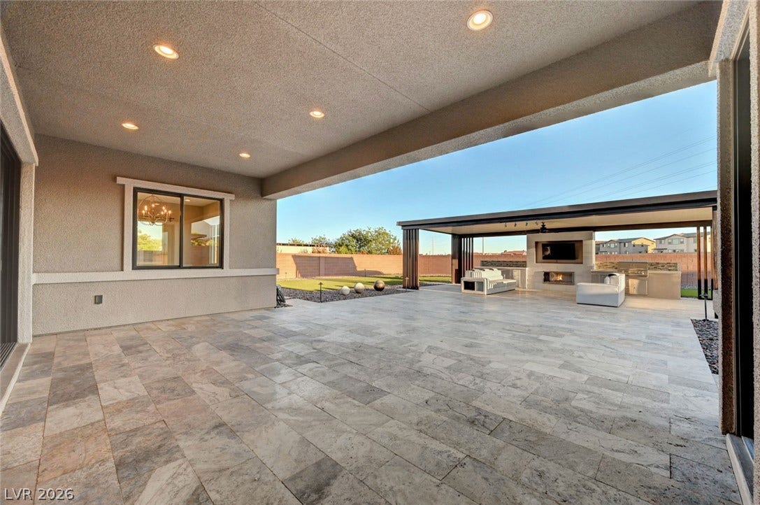 An expansive stone patio integrates seamlessly with the surrounding landscape for effortless outdoor living.