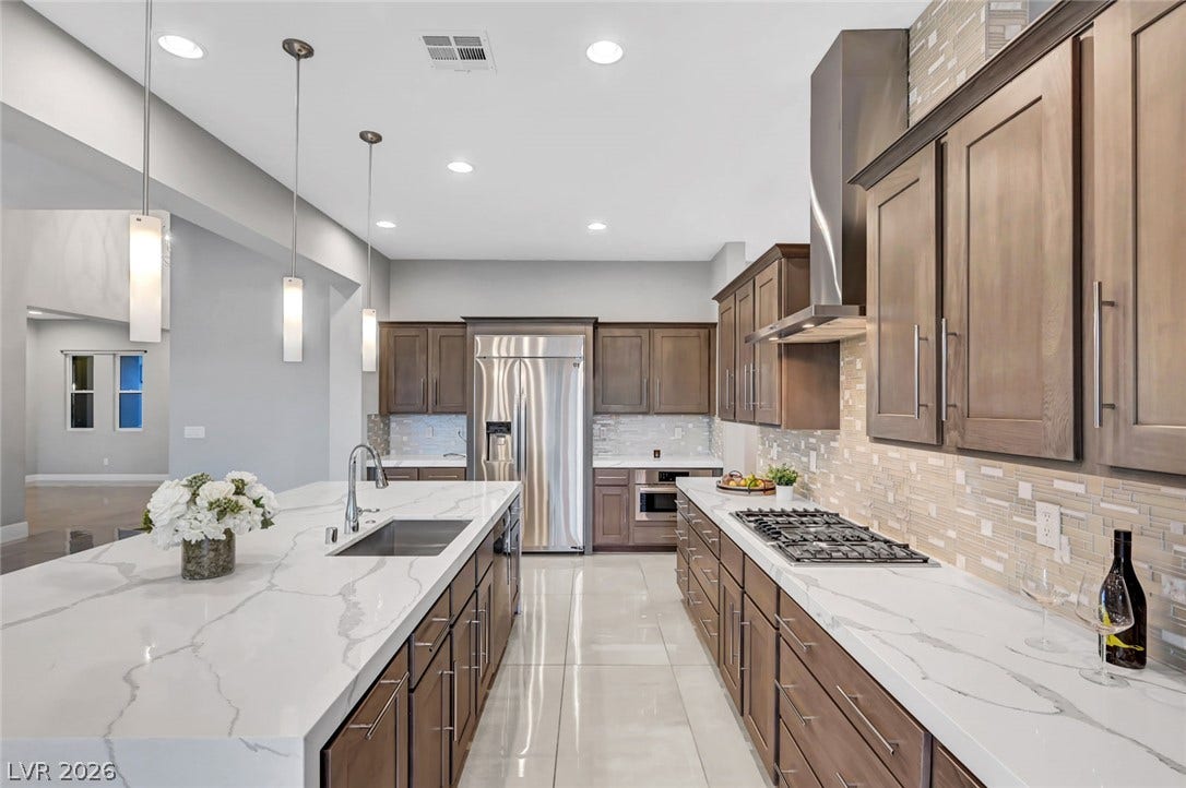 Polished tile flooring and expansive stone countertops define this modern, gourmet kitchen space.