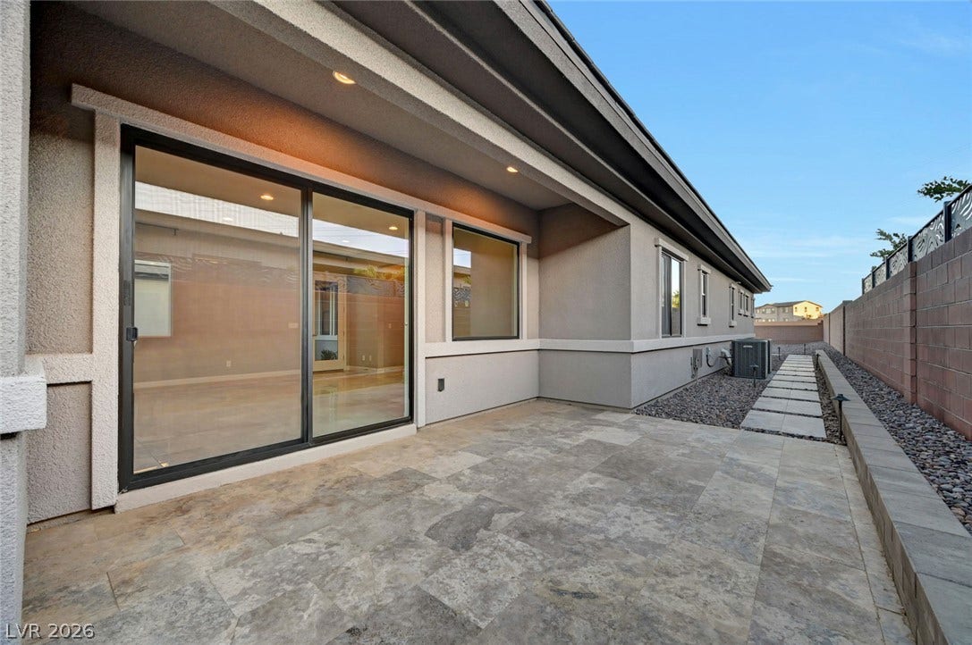 Tiled outdoor flooring under a covered structure leads to a paved side walkway.