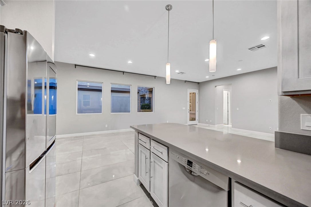 Polished tile flooring and high ceilings elevate this modern open-concept space.
