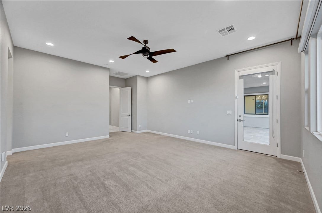 Plush carpeting anchors this versatile room, offering direct access to the outdoors.