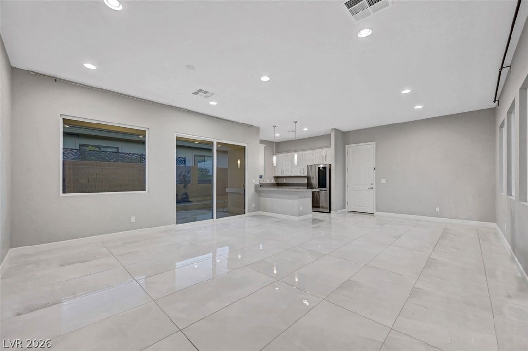 Polished tile flooring and recessed lighting define this open concept interior space.