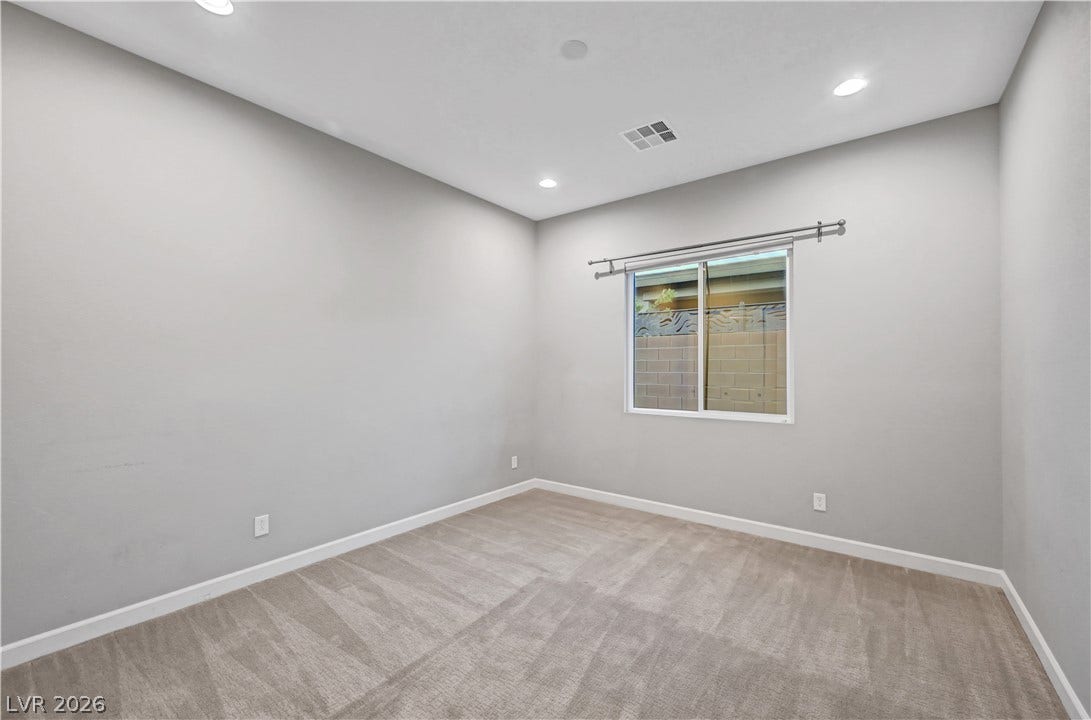 Recessed lighting and soft carpeting create a comfortable atmosphere in this versatile bedroom.