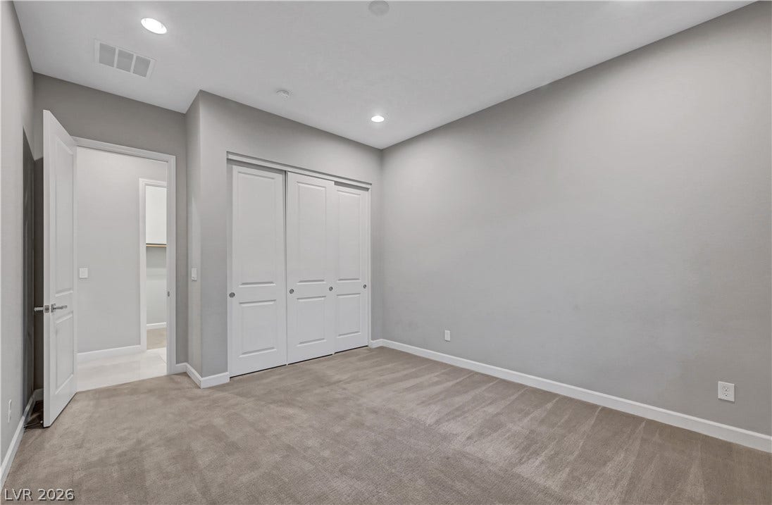 Plush carpeting and modern recessed lighting create a comfortable atmosphere.