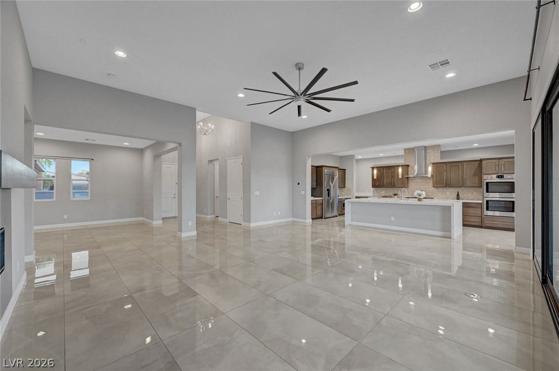 Polished tile flooring flows seamlessly through the airy, open-concept living and kitchen area.