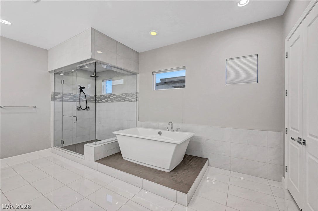 Polished tile flooring and a glass-enclosed shower define this contemporary bath space.
