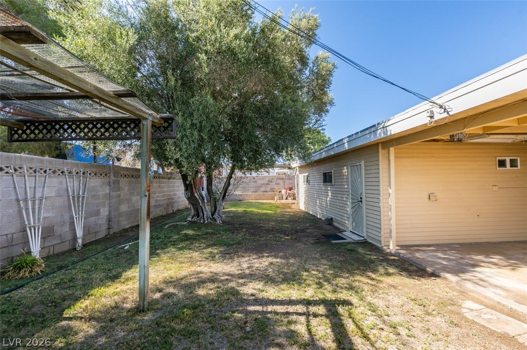 661 Burton Street, Henderson, NV 89015 A spacious backyard area includes a mature tree alongside the detached garage and block fencing.