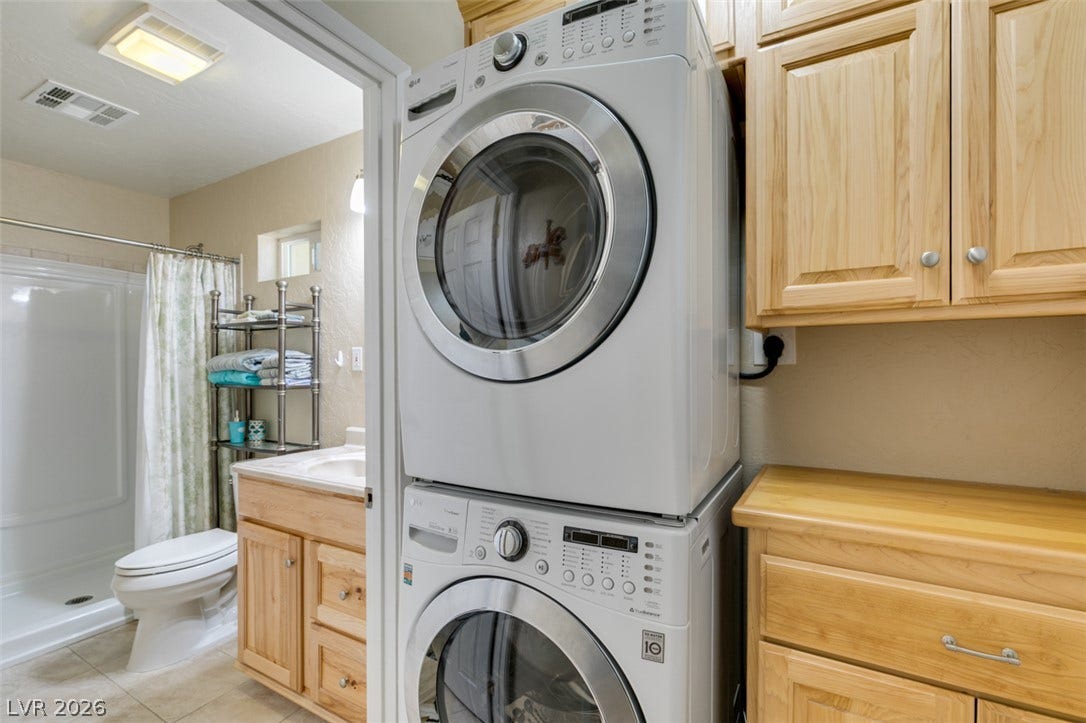 661 Burton Street, Henderson, NV 89015 Stacked laundry appliances and matching wood cabinetry maximize efficiency next to the bathroom.