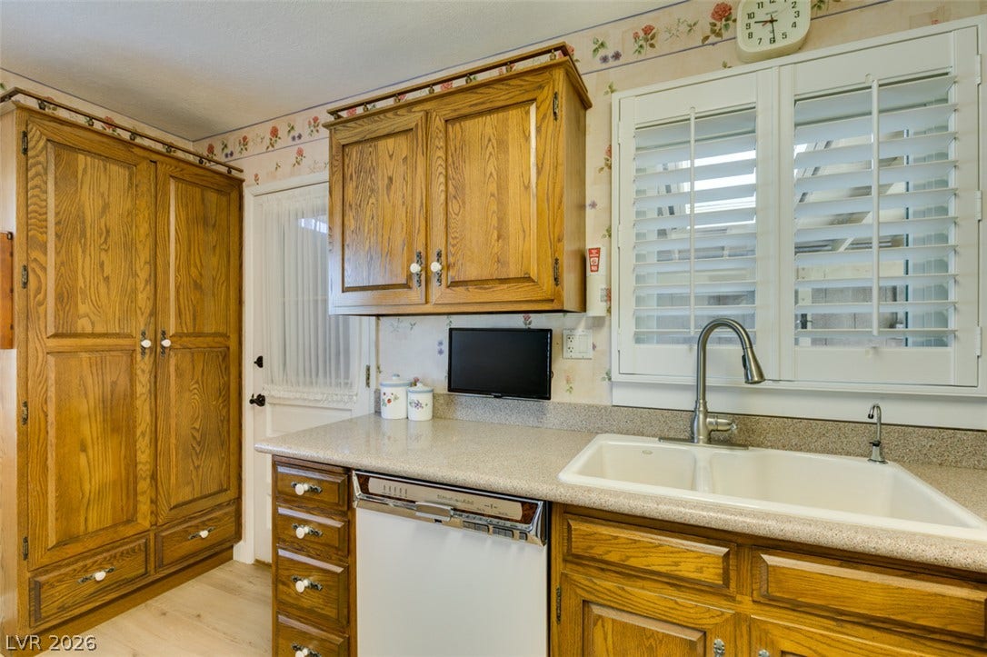 661 Burton Street, Henderson, NV 89015 Oak cabinetry paired with durable solid-surface countertops surrounds the dual-basin kitchen sink.