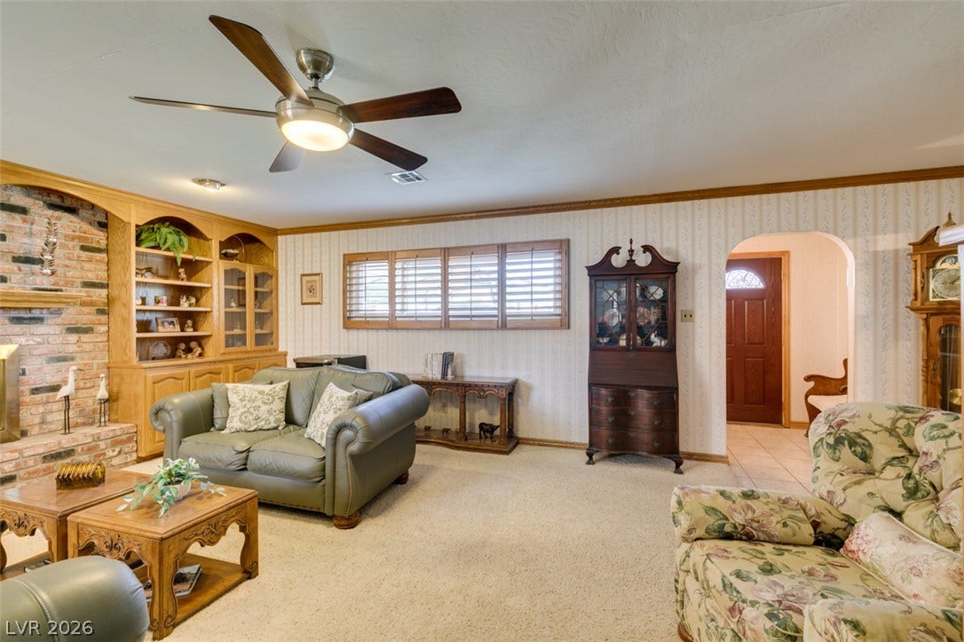 661 Burton Street, Henderson, NV 89015 Crown molding and built-in shelving enhance the architectural character of this carpeted living space.