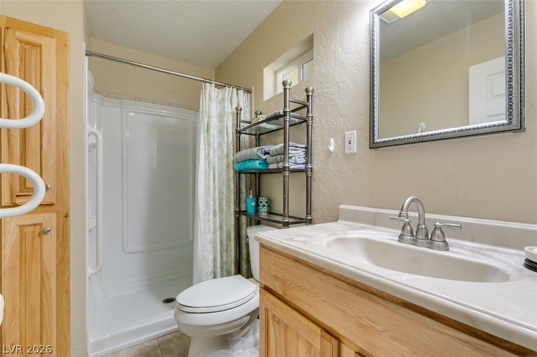 661 Burton Street, Henderson, NV 89015 Natural wood cabinetry and neutral tile flooring complement this functional bathroom space.