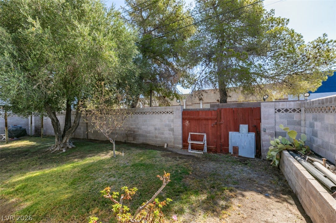 661 Burton Street, Henderson, NV 89015 Mature trees offer natural shade over the grassy yard enclosed by durable masonry block walls.