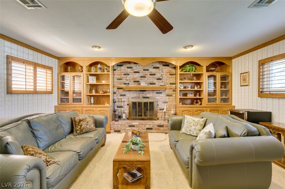 661 Burton Street, Henderson, NV 89015 A handsome brick fireplace and custom built-ins anchor this inviting living space.