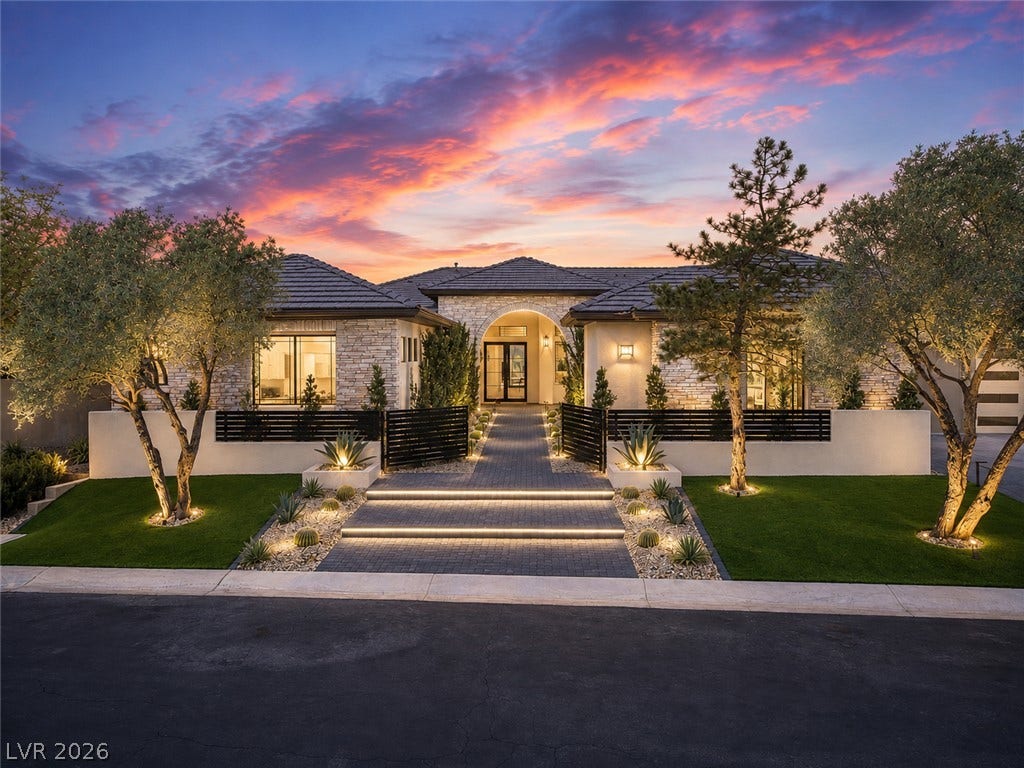 3 Pine Hollow Drive, Henderson, NV 89052 Dramatic up-lighting illuminates the stone facade, gated entry, and manicured desert landscaping of this modern estate.