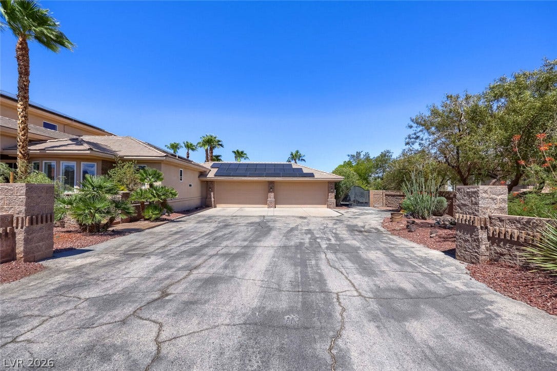 2807 Richmar Avenue, Henderson, NV 89074 An expansive paved driveway leads to a multi-car garage equipped with rooftop solar panels.