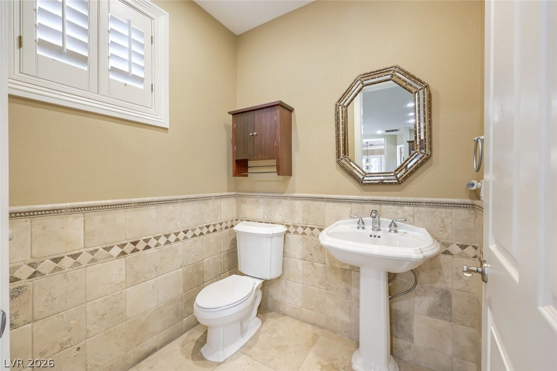 2807 Richmar Avenue, Henderson, NV 89074 Tiled wainscoting and a classic pedestal sink define this charming powder room.