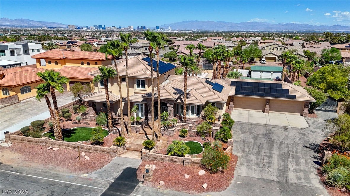 2807 Richmar Avenue, Henderson, NV 89074 An expansive driveway leads to a multi-car garage beneath a tile roof with solar panels.