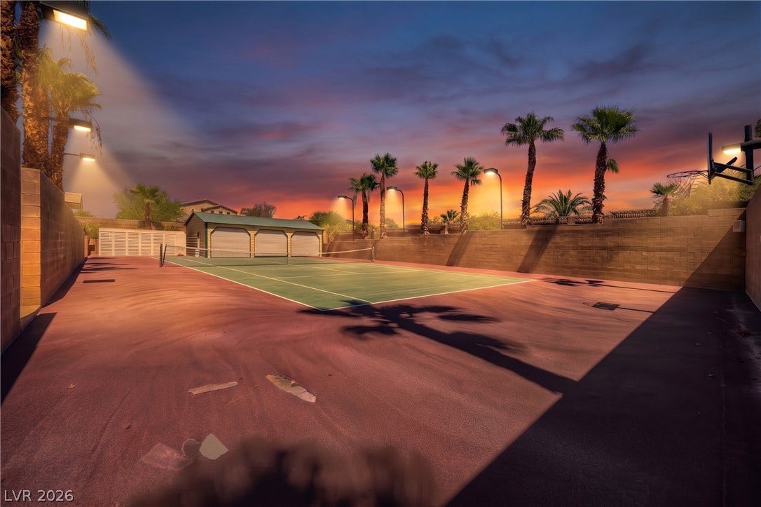 2807 Richmar Avenue, Henderson, NV 89074 Private sports court with basketball and tennis facilities set against a dramatic evening sky.