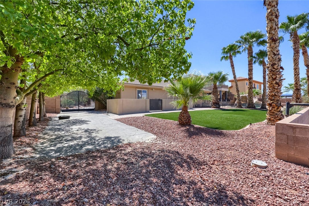2807 Richmar Avenue, Henderson, NV 89074 Lush trees and majestic palms frame a private gated driveway leading to the home.