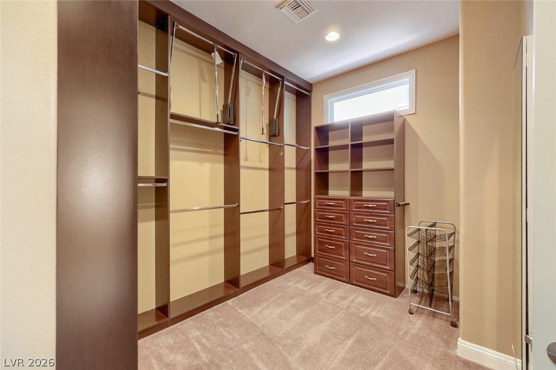 2807 Richmar Avenue, Henderson, NV 89074 Custom built-in shelving and ample hanging rods maximize storage in this carpeted walk-in closet.