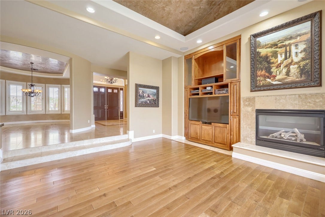 2807 Richmar Avenue, Henderson, NV 89074 Warm hardwood floors and a modern fireplace define this inviting open living space.