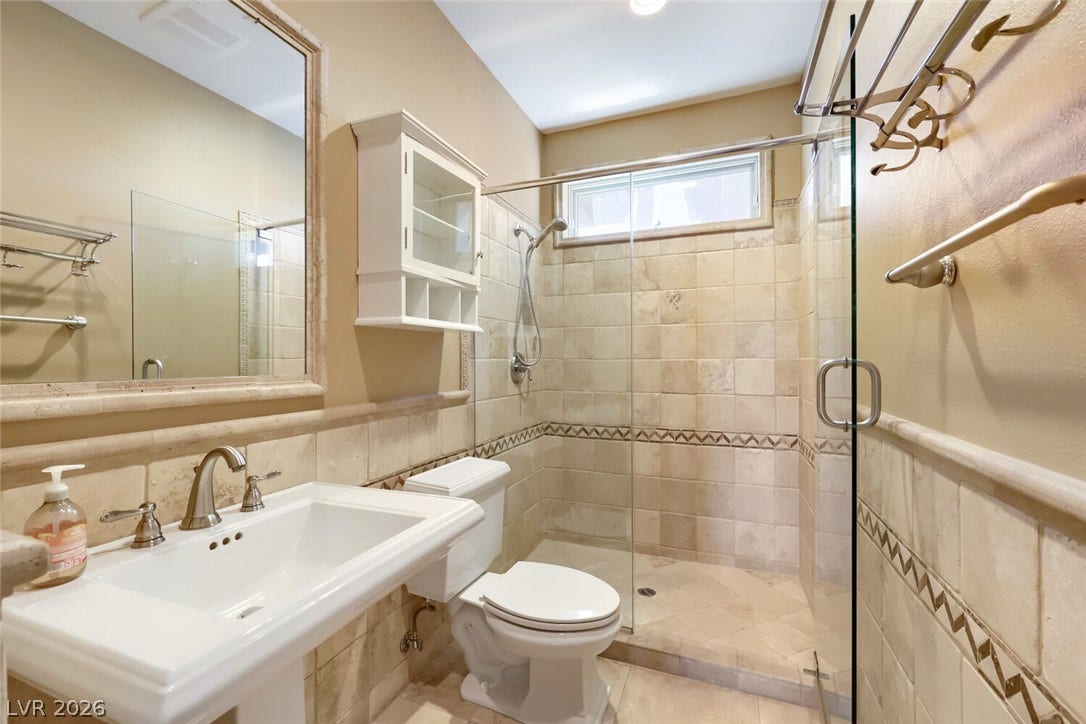 2807 Richmar Avenue, Henderson, NV 89074 Tiled walls and a glass-enclosed shower define this functional bathroom space.