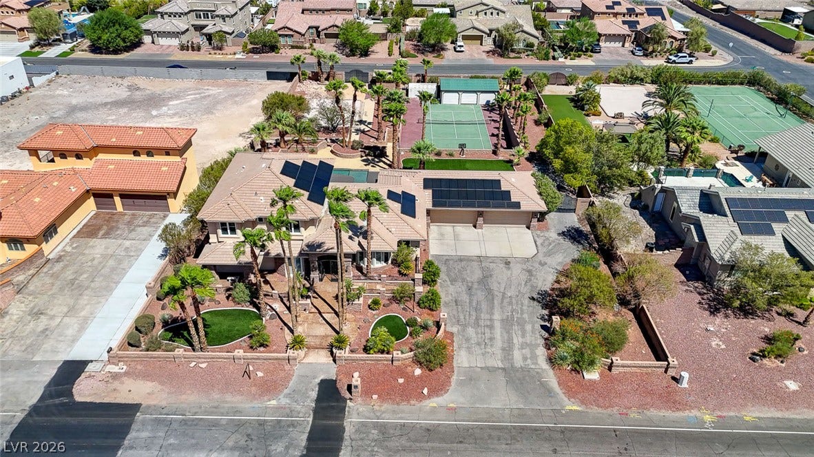 2807 Richmar Avenue, Henderson, NV 89074 An aerial perspective showcases a sprawling suburban estate featuring solar panels and manicured desert landscaping.