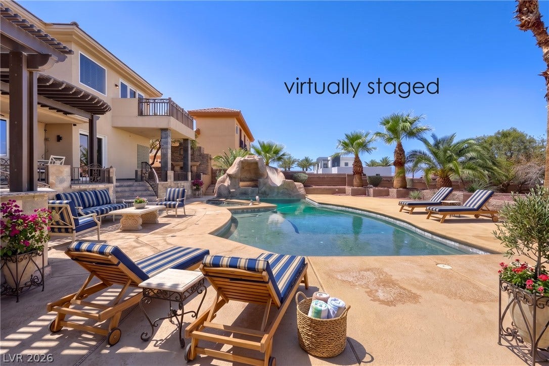 2807 Richmar Avenue, Henderson, NV 89074 An inviting backyard oasis features a custom swimming pool framed by towering palm trees.