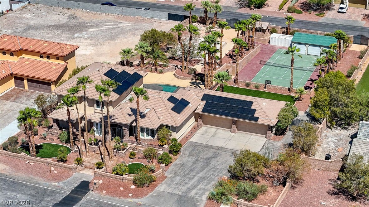 2807 Richmar Avenue, Henderson, NV 89074 An aerial perspective showcases an expansive residential estate featuring integrated rooftop solar panels and tennis courts.