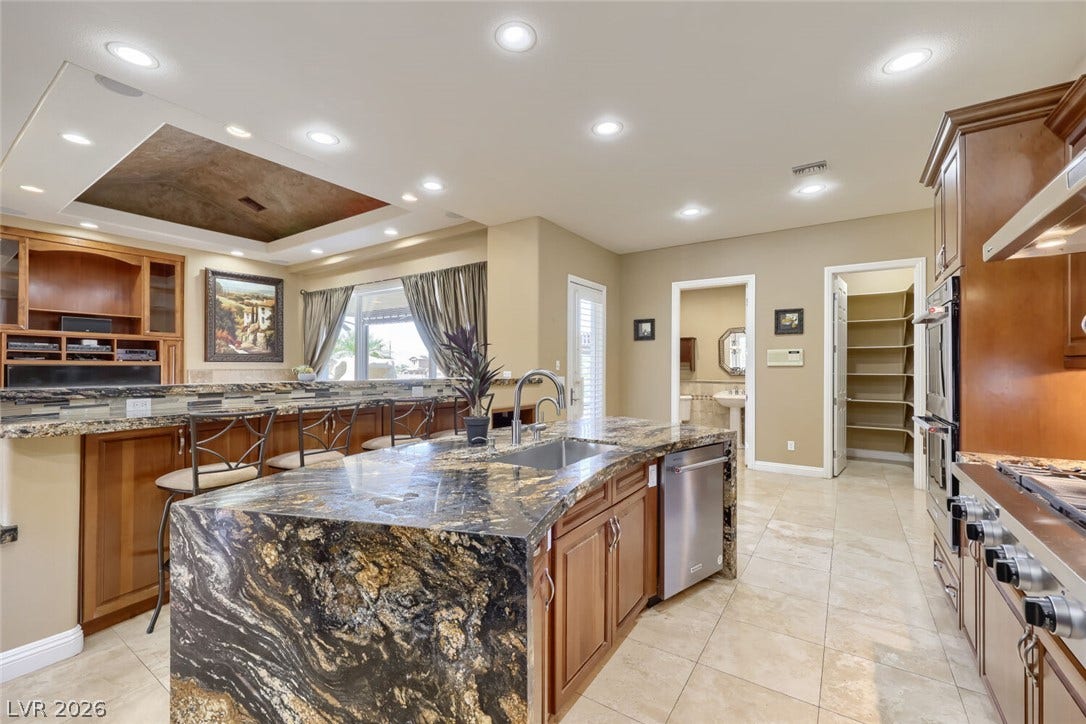 2807 Richmar Avenue, Henderson, NV 89074 Gleaming stone countertops and a spacious central island anchor this custom kitchen design.