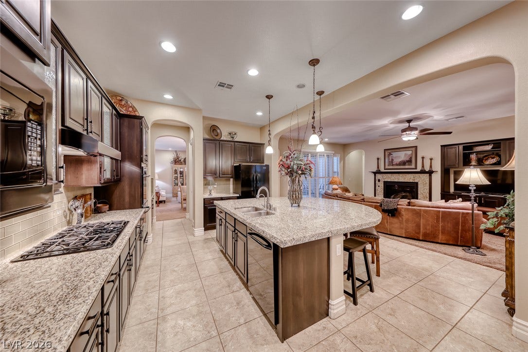 41 Moltrasio Lane, Henderson, NV 89011 Gleaming stone countertops and a spacious island flow seamlessly into the adjacent living space.