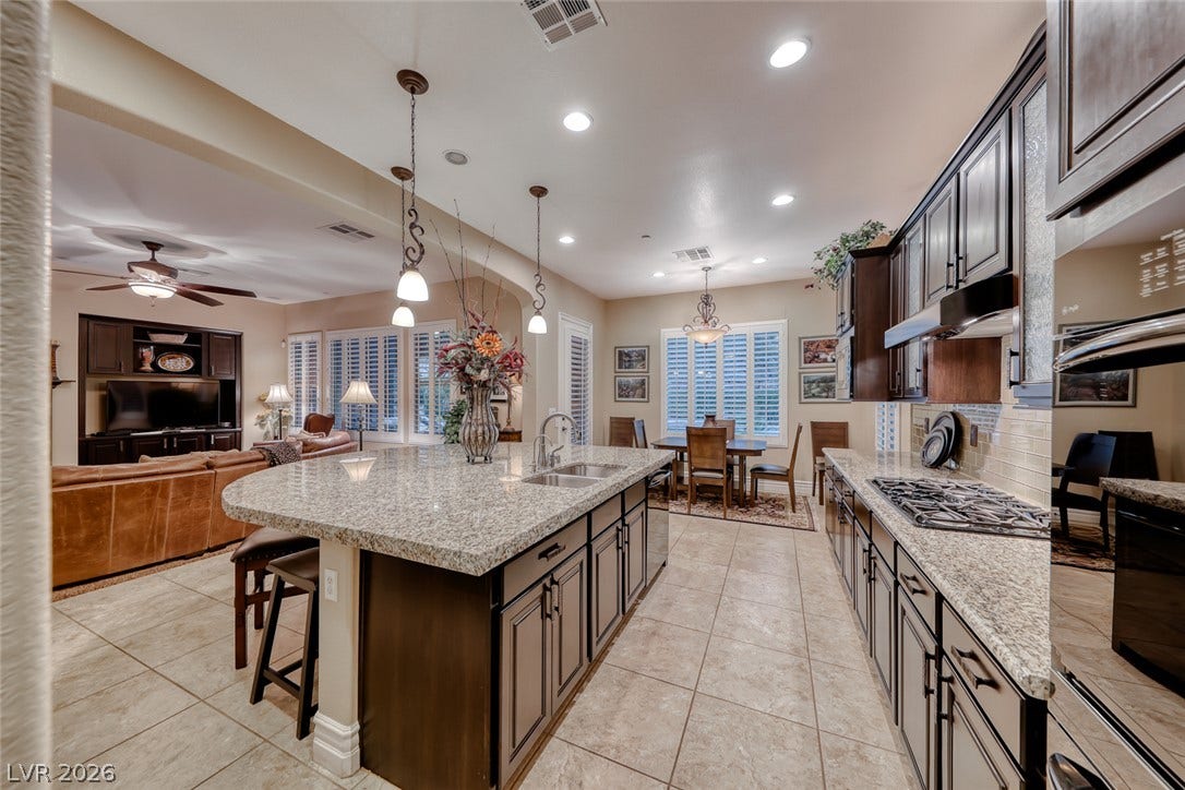41 Moltrasio Lane, Henderson, NV 89011 Gleaming granite countertops pair beautifully with rich dark cabinetry in this open kitchen.