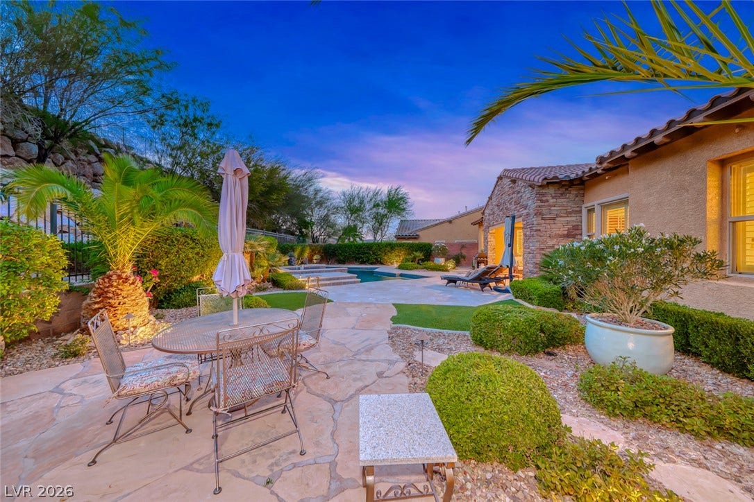 41 Moltrasio Lane, Henderson, NV 89011 Lush landscaping and stone pathways create a tranquil desert oasis in this backyard retreat.