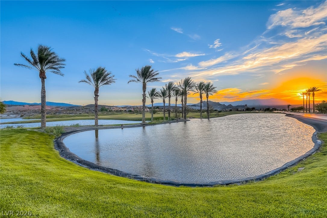 41 Moltrasio Lane, Henderson, NV 89011 Palm trees line the tranquil community lake as sunset paints the desert sky.