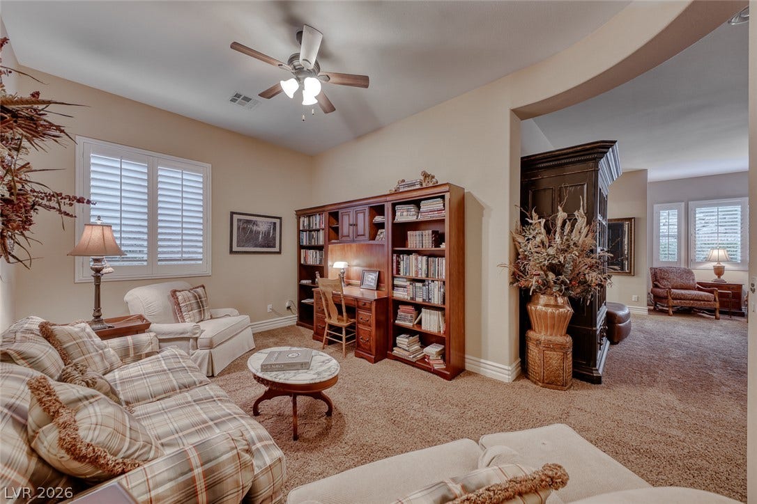 41 Moltrasio Lane, Henderson, NV 89011 An arched doorway leads into a cozy home office featuring a built-in bookcase.