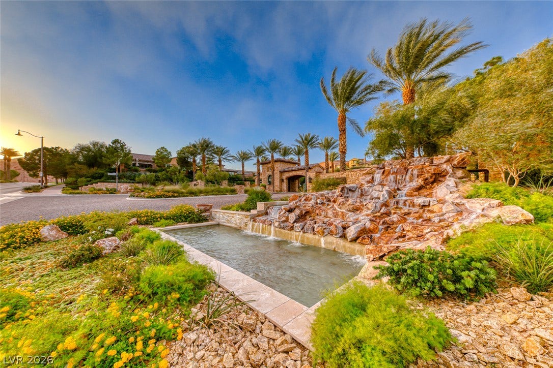 41 Moltrasio Lane, Henderson, NV 89011 A stone water feature and palm trees frame the entrance to this gated neighborhood.