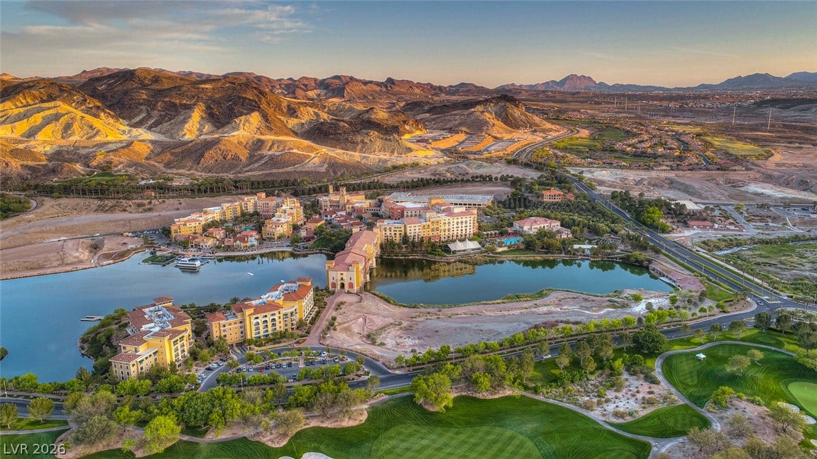 41 Moltrasio Lane, Henderson, NV 89011 Panoramic lakeside views showcase Mediterranean-style architecture nestled against a dramatic mountain backdrop.