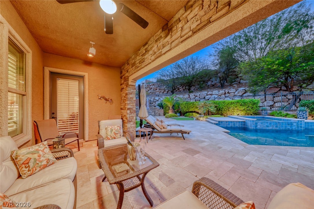 41 Moltrasio Lane, Henderson, NV 89011 A stone-accented covered patio overlooks the tiled swimming pool and landscaped terraced backyard.