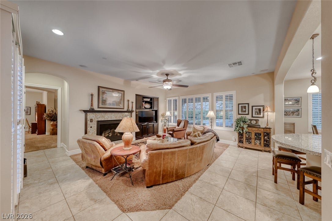 41 Moltrasio Lane, Henderson, NV 89011 Tile flooring leads past a cozy fireplace into an open living and dining layout.