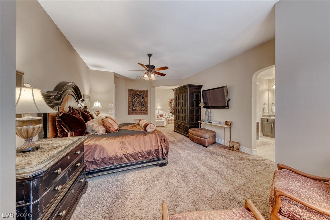 41 Moltrasio Lane, Henderson, NV 89011 Plush carpeting anchors this spacious bedroom suite featuring an arched transition to the adjoining bath.