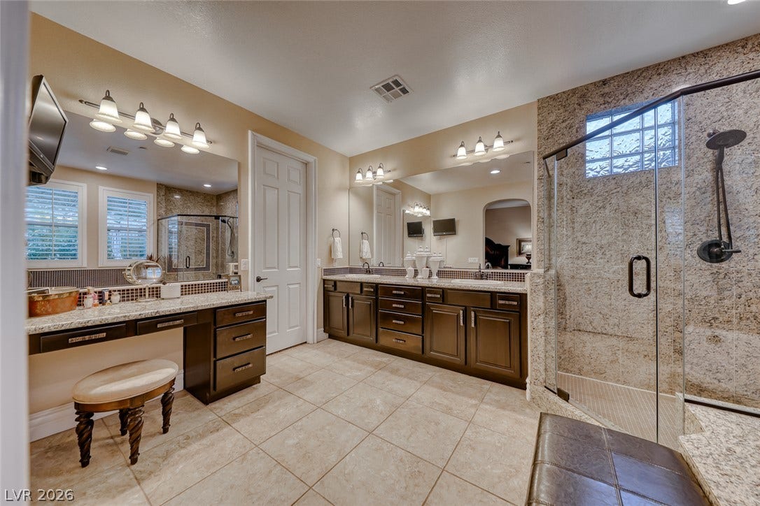 41 Moltrasio Lane, Henderson, NV 89011 Fine stone surfaces and matching dual vanities elevate this generous master bath space.